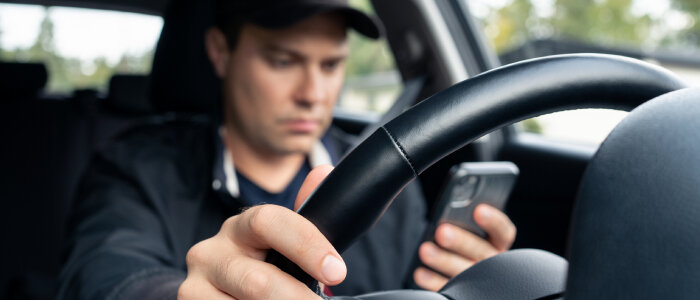 A man looking at his phone while driving