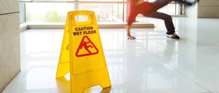 A person slips with a caution slip and fall sign