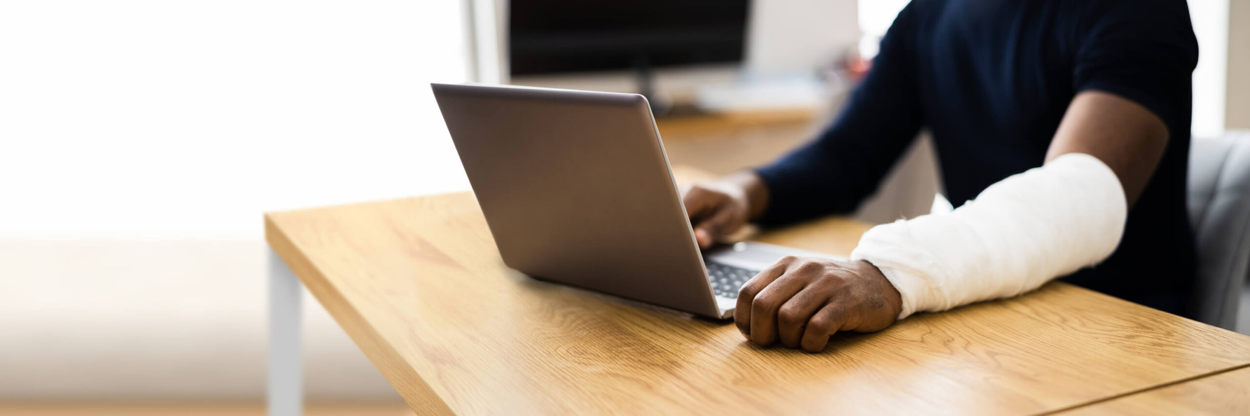 Injured Worker Compensation. Broken Arm African Man On Computer