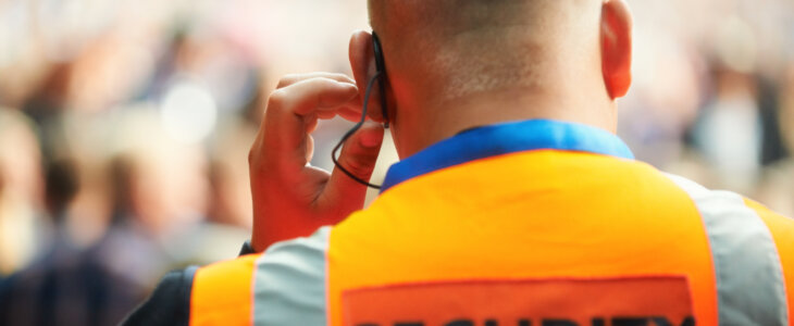 Rear view of a security guard listening to his headset