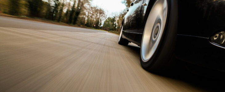 Side view of black car driving fast.