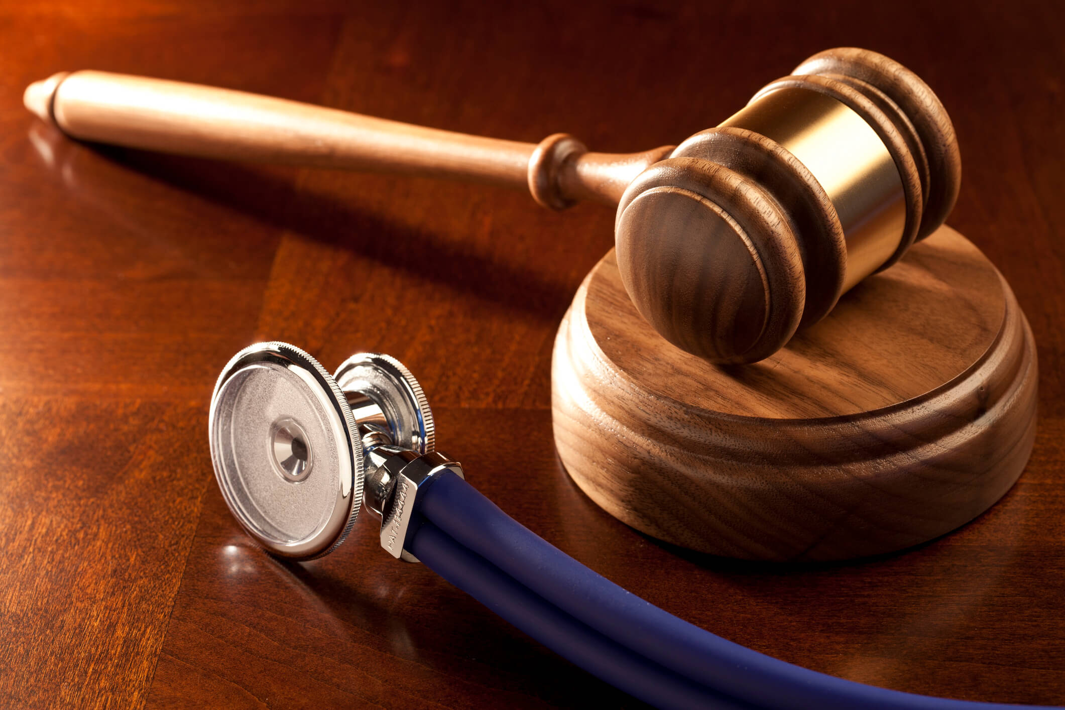 Contributory negligence vs comparative negligence decided in an injury case, shown by a gavel and stethoscope