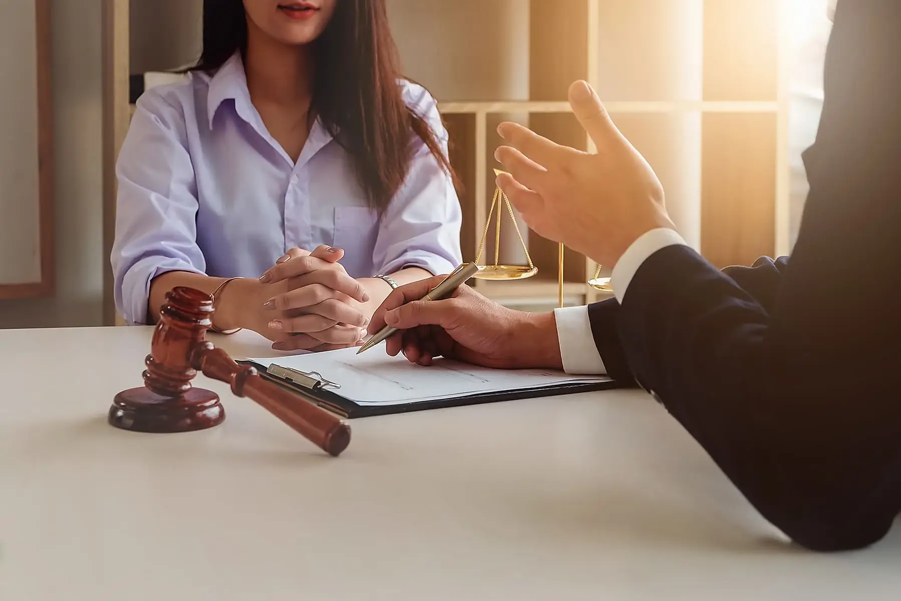 Columbus, GA personal injury lawyer consulting with an injured client at a desk with a gavel